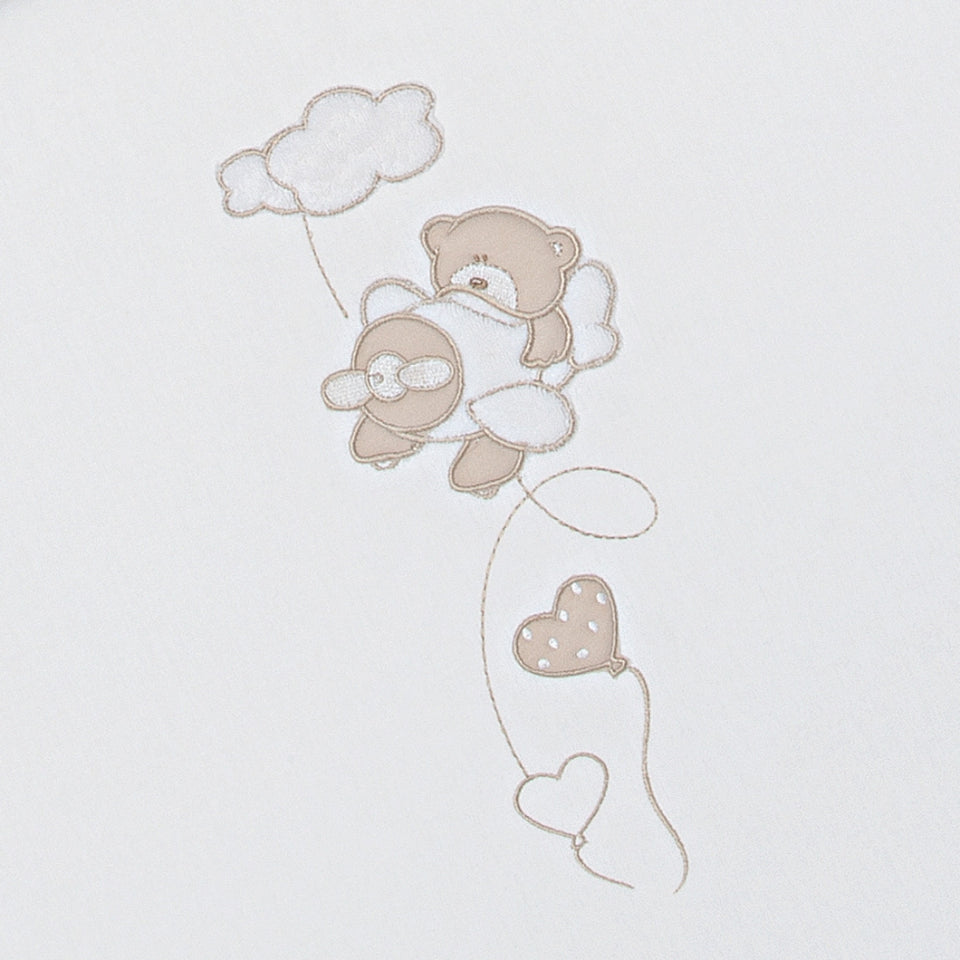 Closeup of the BabyFly duvet set for babycot featuring embroidery with a cute teddy bear flying on an aeroplane. 
